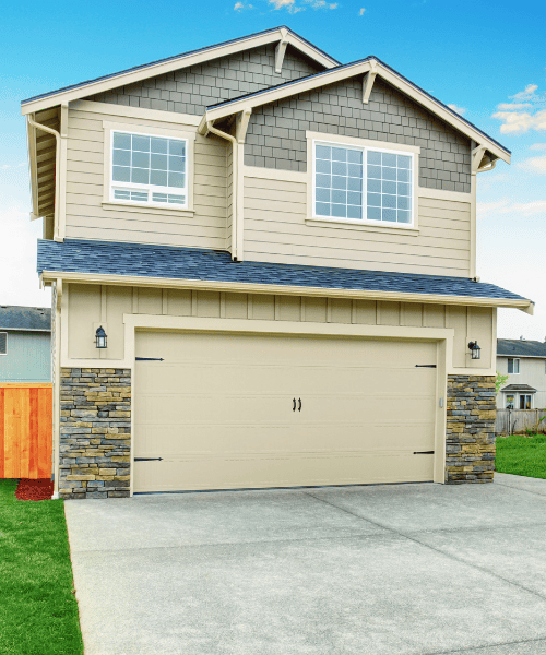 Palm Beach Concrete. A two-story house featuring a garage and a spacious driveway, showcasing a welcoming residential environment.